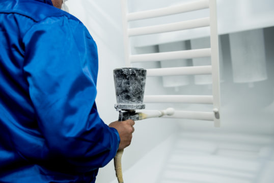 worker performing powder coating