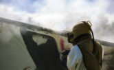 man in protective gear sandblasting