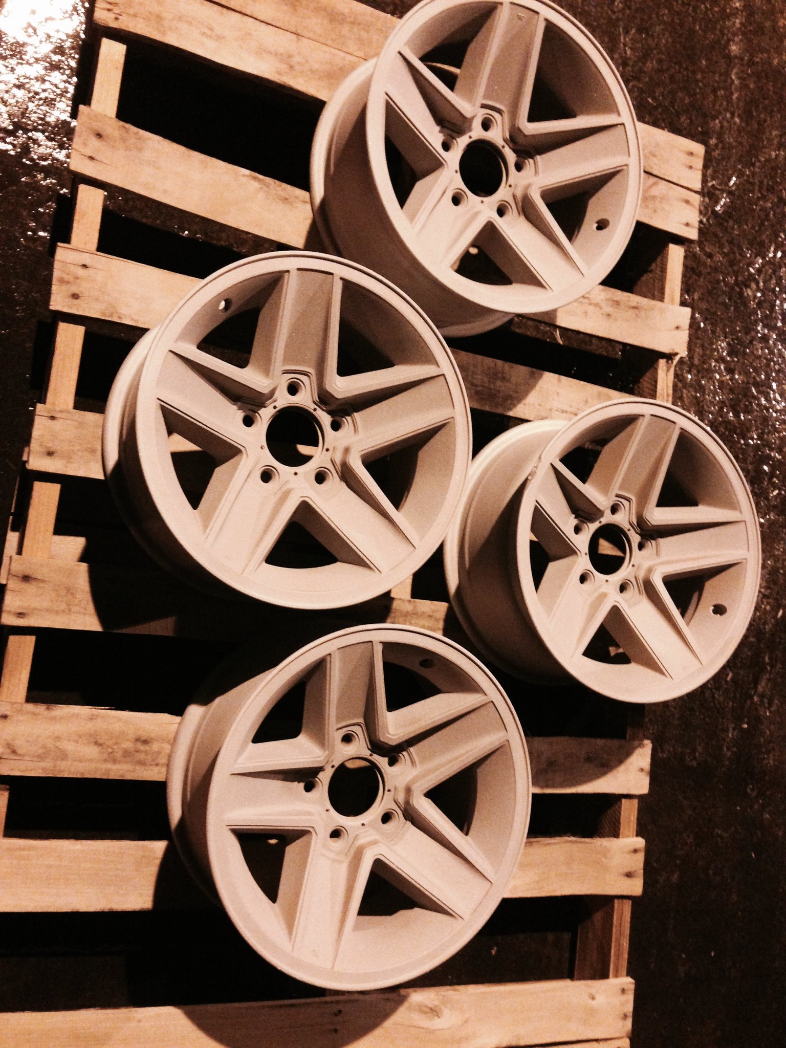 4 car wheels resting on a wooden pallet