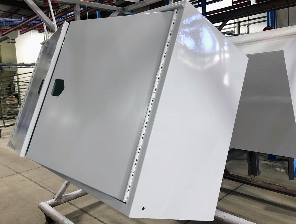 Large industrial steel cabinet with light grey powder coating on a factory floor